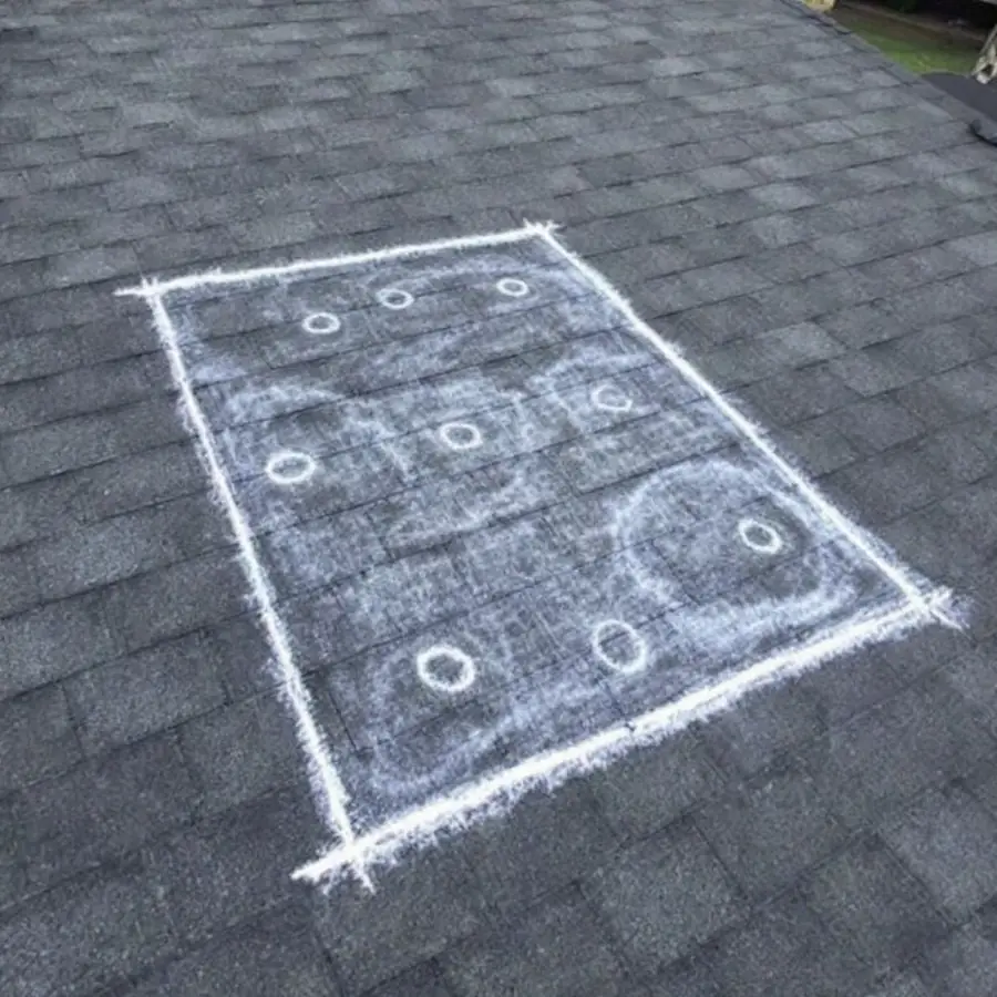 Asphalt shingle roof with a large square marked out in white chalk and individual impact marks circled inside it