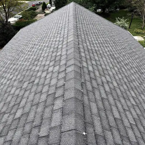 Finished new architectural asphalt shingle roof with straight even courses and a clean ridge, seen at an angle from above